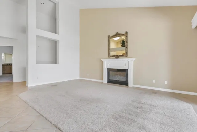 an empty room with a fireplace and a window