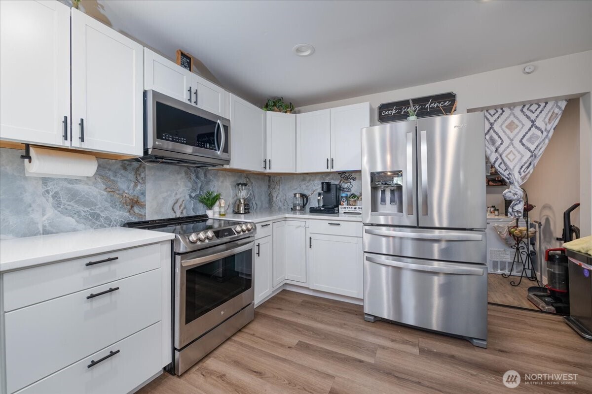 533 Fidalgo Street Sedro-Woolley, WA 98284 - Photo 8 of 37 a kitchen with stainless steel appliances granite countertop a refrigerator stove and white cabinets