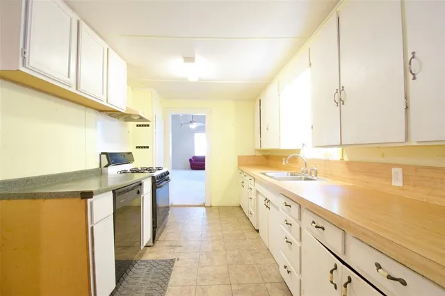 a large kitchen with stainless steel appliances granite countertop a sink and cabinets