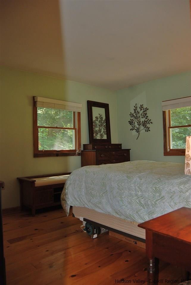 79 Iken Road Kerhonkson, NY 12446 - Photo 15 of 24 a bedroom with a bed and wooden floor