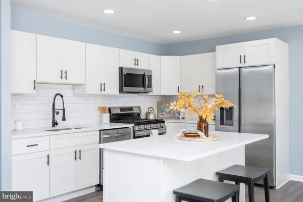 a kitchen with appliances a sink cabinets and a counter top space