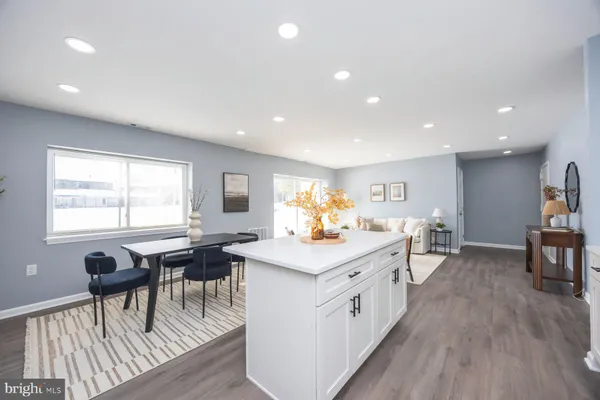 a kitchen with a stove a sink a dining table and chairs with wooden floor