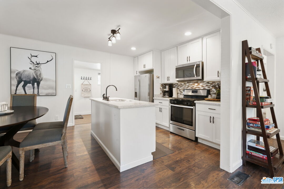 53335 Meadow Drive Idyllwild, CA 92549 - Photo 12 of 35 a kitchen with white cabinets stainless steel appliances and wooden floor