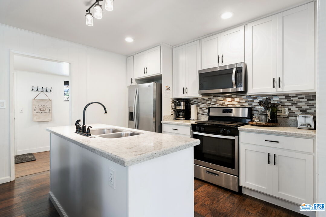 53335 Meadow Drive Idyllwild, CA 92549 - Photo 13 of 35 a kitchen with stainless steel appliances granite countertop a stove a sink dishwasher a refrigerator and a microwave oven with wooden floor