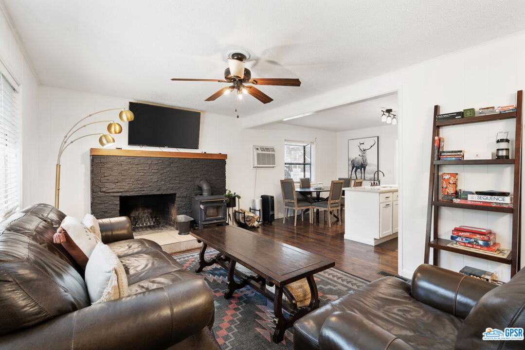 53335 Meadow Drive Idyllwild, CA 92549 - Photo 9 of 35 a living room with furniture a flat screen tv and a fireplace