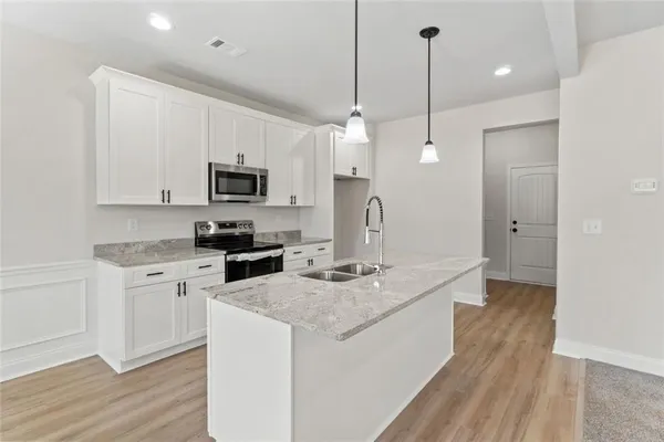 a kitchen with a sink a microwave a stove and refrigerator