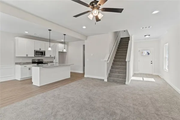 a view of kitchen with refrigerator and microwave