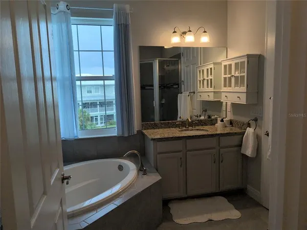a bathroom with a tub sink and mirror
