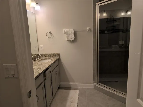a bathroom with a granite countertop sink and mirror