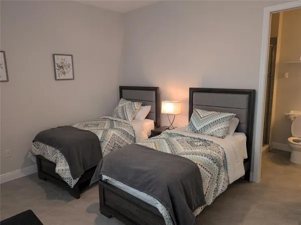 a bedroom with two beds and painting on the wall
