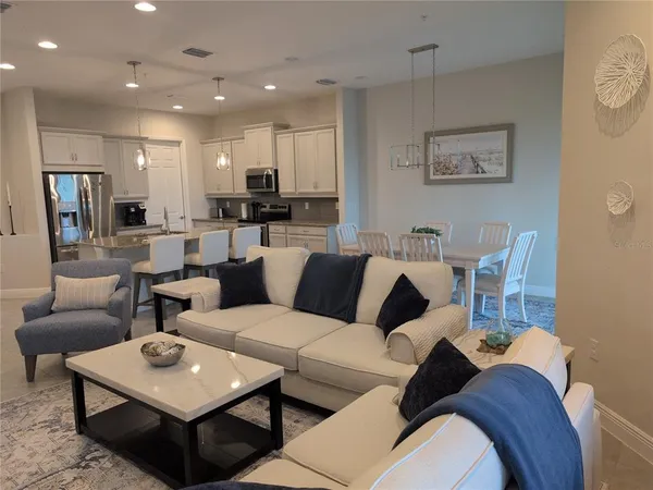 a living room with furniture a rug and kitchen view