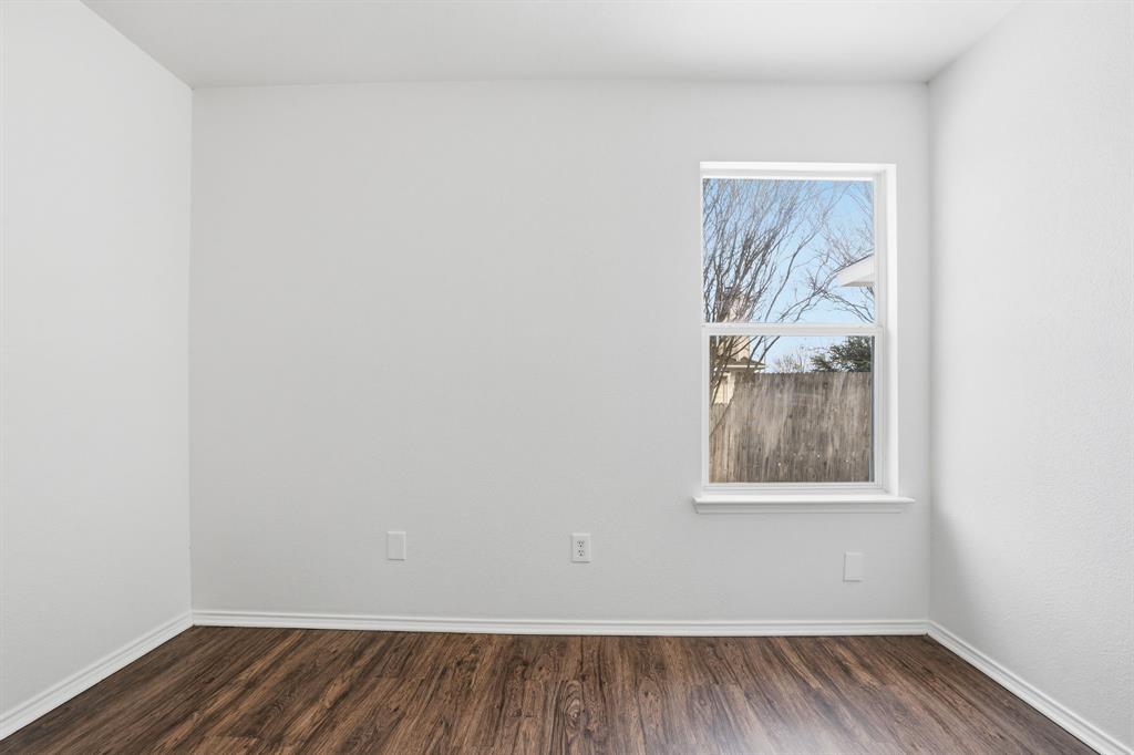 1000 Caleb Street Burleson, TX 76028 - Photo 13 of 27 a view of an empty room with wooden floor and a window