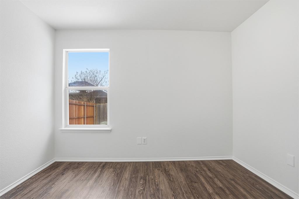 1000 Caleb Street Burleson, TX 76028 - Photo 14 of 27 a view of an empty room with wooden floor and a window