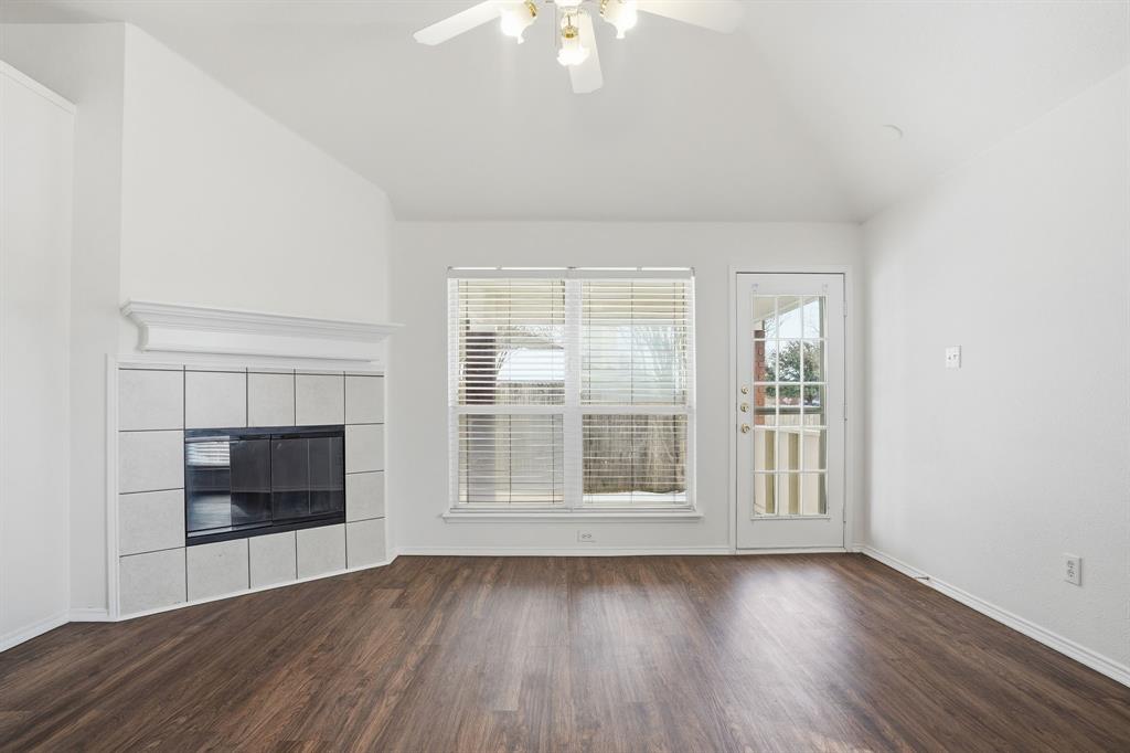1000 Caleb Street Burleson, TX 76028 - Photo 4 of 27 an empty room with wooden floor fire place and windows