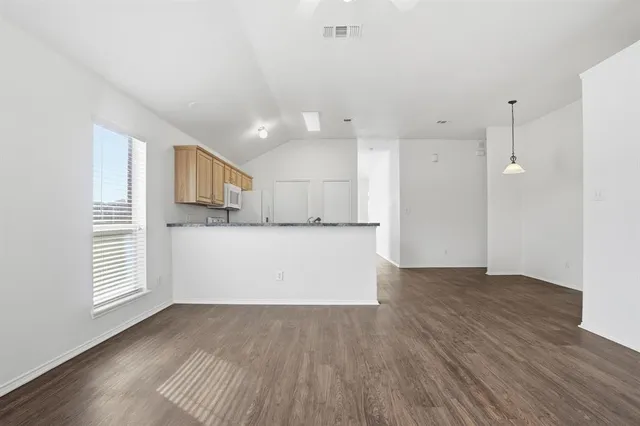 a view of kitchen with wooden floor and electronic appliances