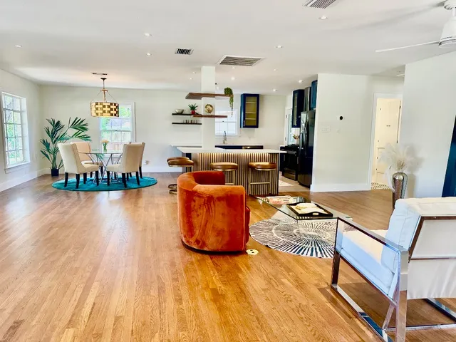 a living room with furniture and a wooden floor