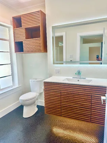 a bathroom with a sink a toilet and a mirror