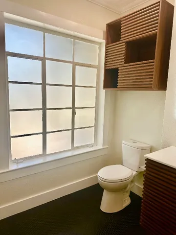 a bathroom with a toilet a sink and a window