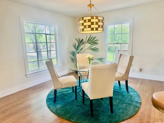 a view of a dining room with furniture a chandelier and wooden floor
