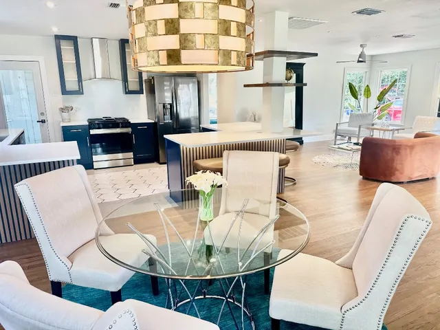 a dining room with furniture a kitchen and chandelier