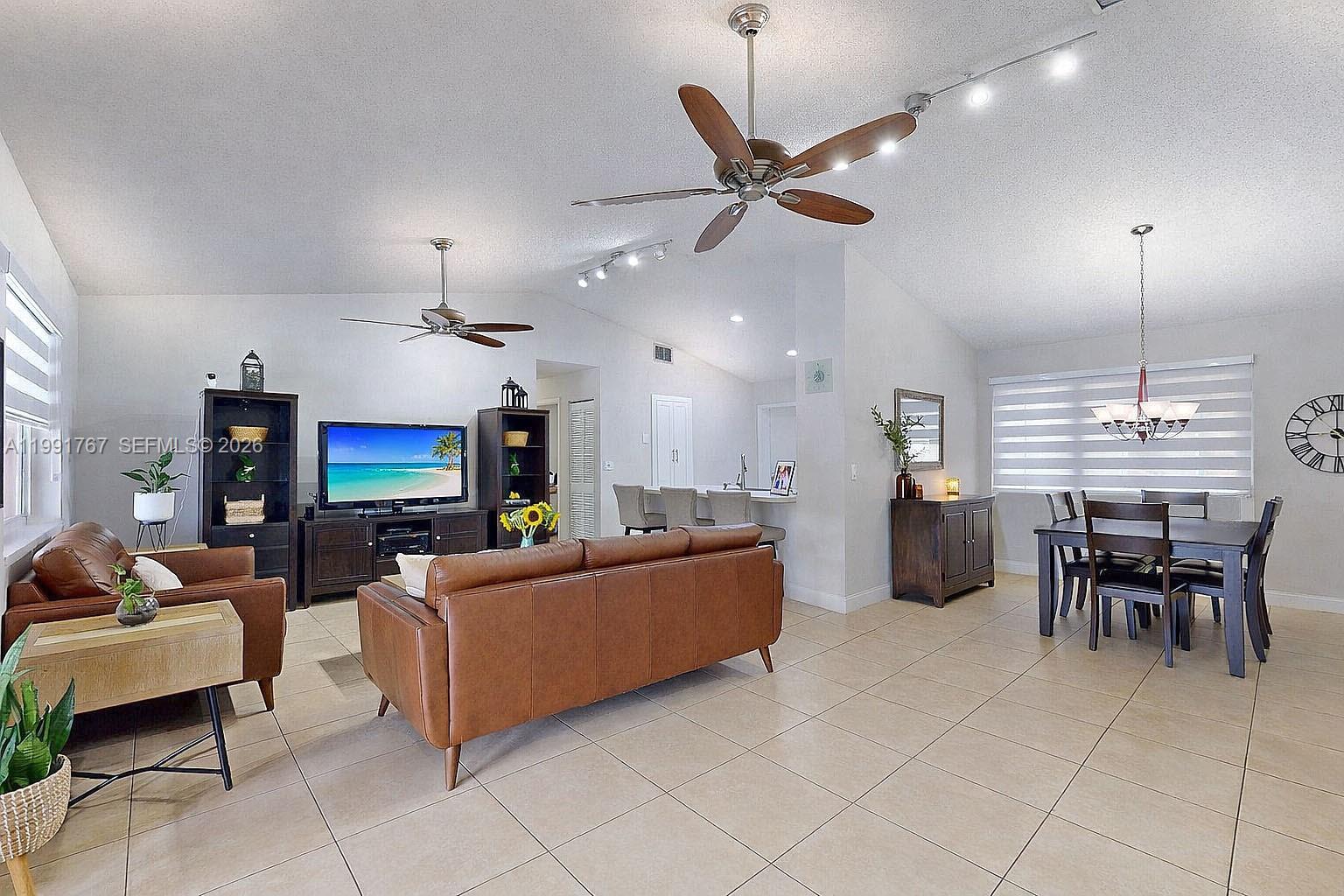 15382 Southwest 153rd Street Miami, FL 33187 - Photo 26 of 65 a living room with furniture a dining table and a fireplace
