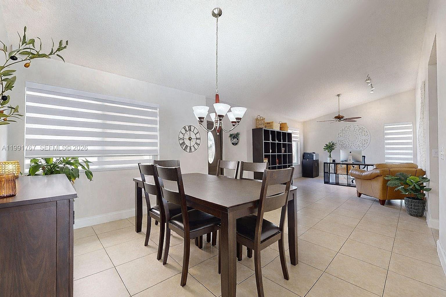 15382 Southwest 153rd Street Miami, FL 33187 - Photo 29 of 65 a dining room filled a chandelier and kitchen view
