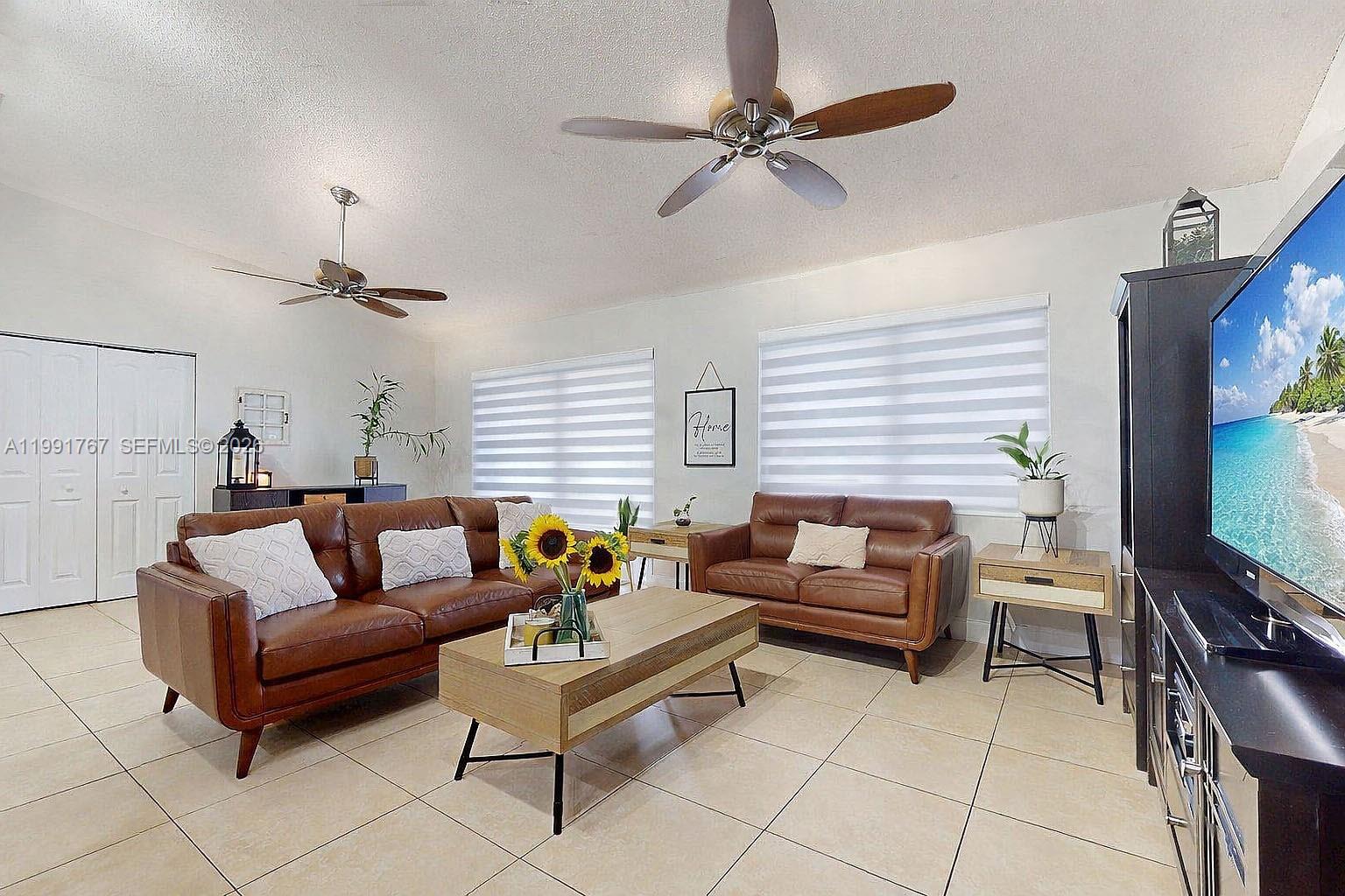 15382 Southwest 153rd Street Miami, FL 33187 - Photo 30 of 65 a living room with furniture and a flat screen tv