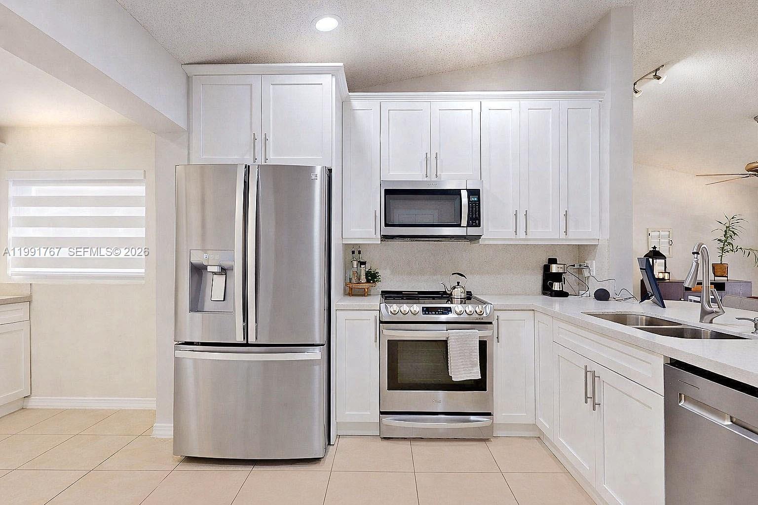 15382 Southwest 153rd Street Miami, FL 33187 - Photo 35 of 65 a kitchen with cabinets stainless steel appliances and a window