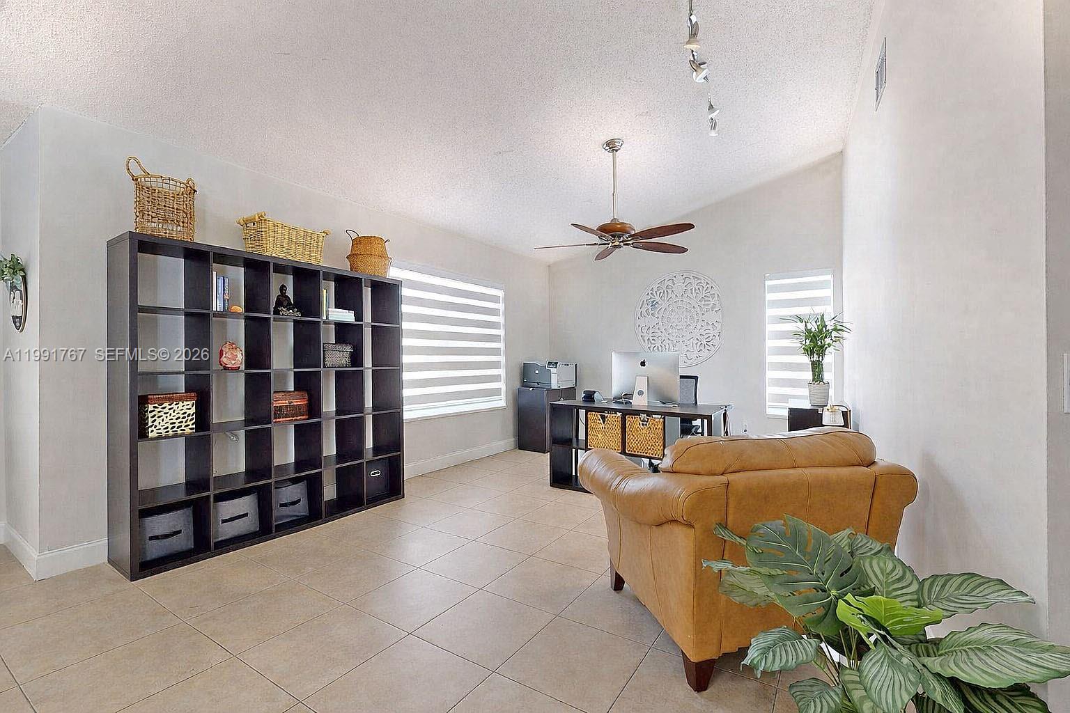 15382 Southwest 153rd Street Miami, FL 33187 - Photo 42 of 65 a living room with furniture cabinets and book shelf