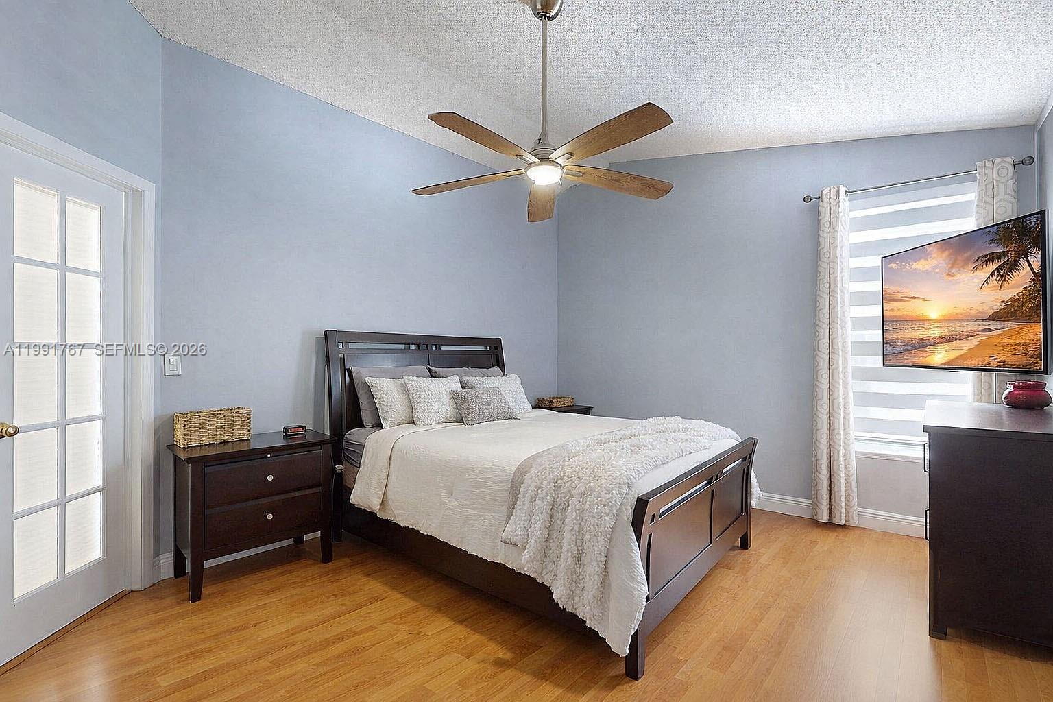 15382 Southwest 153rd Street Miami, FL 33187 - Photo 44 of 65 a bedroom with a bed and a flat tv screen on dresser