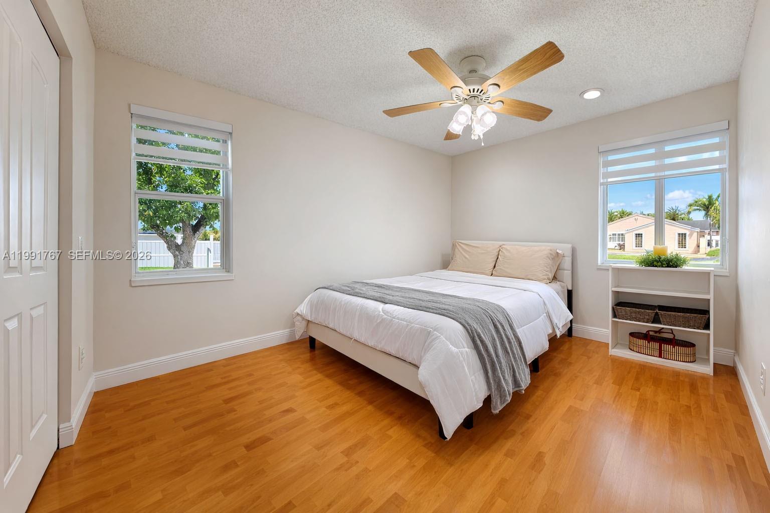 15382 Southwest 153rd Street Miami, FL 33187 - Photo 50 of 65 a bedroom with a bed and a ceiling fan