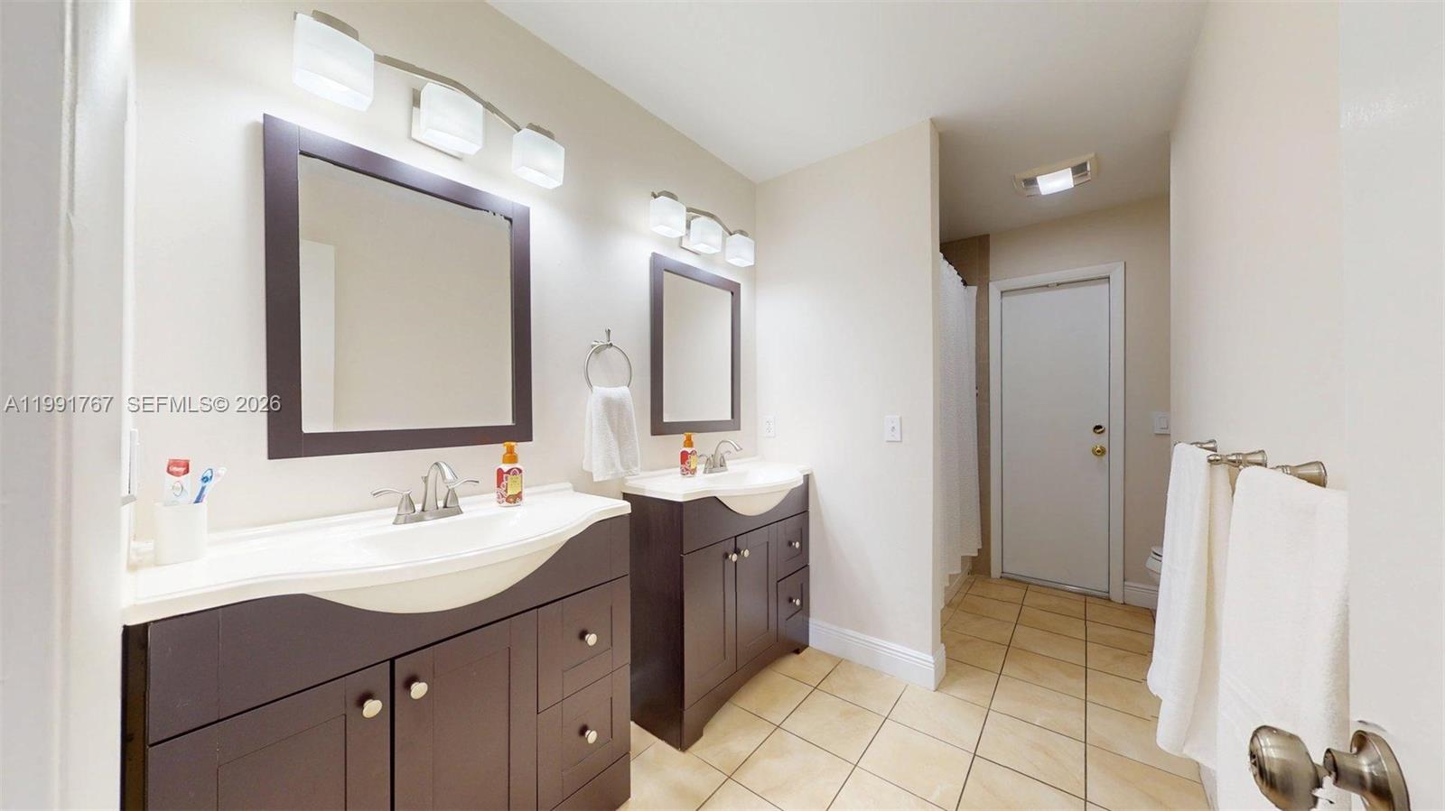 15382 Southwest 153rd Street Miami, FL 33187 - Photo 53 of 65 a spacious bathroom with a double vanity sink mirror and shower