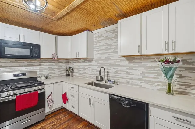 a kitchen with sink cabinets and stove top oven