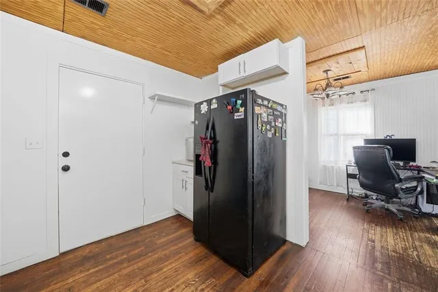 a view of a hallway with wooden floor and furniture