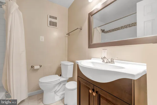 a bathroom with a sink toilet and mirror