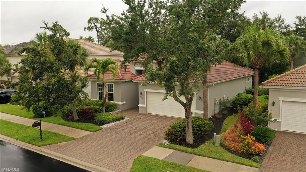 16188 Parque Lane Naples, FL 34110 - Photo 2 of 15 a front view of a house with garden