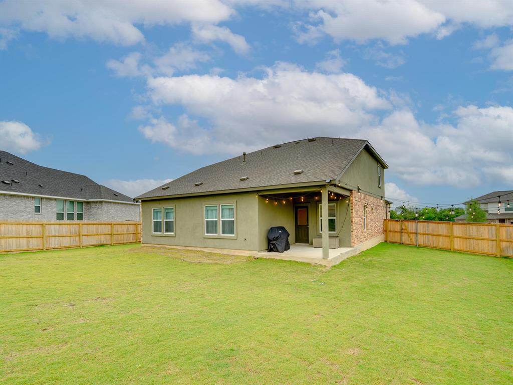 1208 Sweetspire Street Leander, TX 78641 - Photo 29 of 36 Expansive backyard featuring a covered patio, brick and stucco exterior, and wood fencing