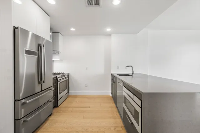 a kitchen with stainless steel appliances granite countertop a refrigerator and a sink