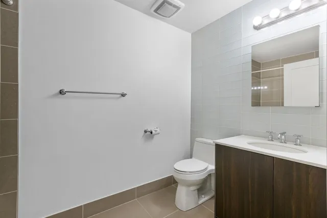 a bathroom with a sink a toilet and a mirror