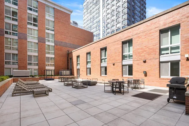 a building outdoor space with patio furniture and barbeque oven