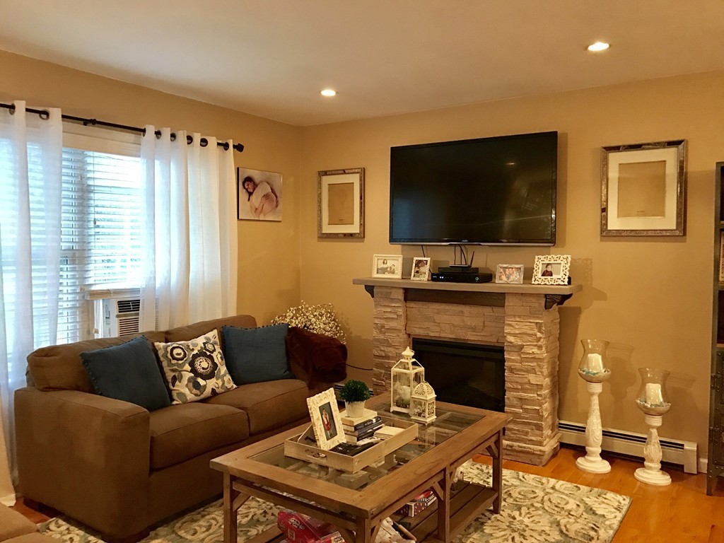 3 Diamond Street Fairhaven, MA 02719 - Photo 5 of 17 a living room with furniture a flat screen tv and a fireplace