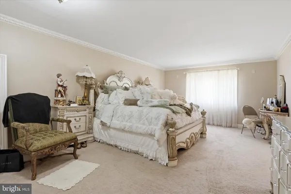 a spacious bedroom with a bed a table and chair