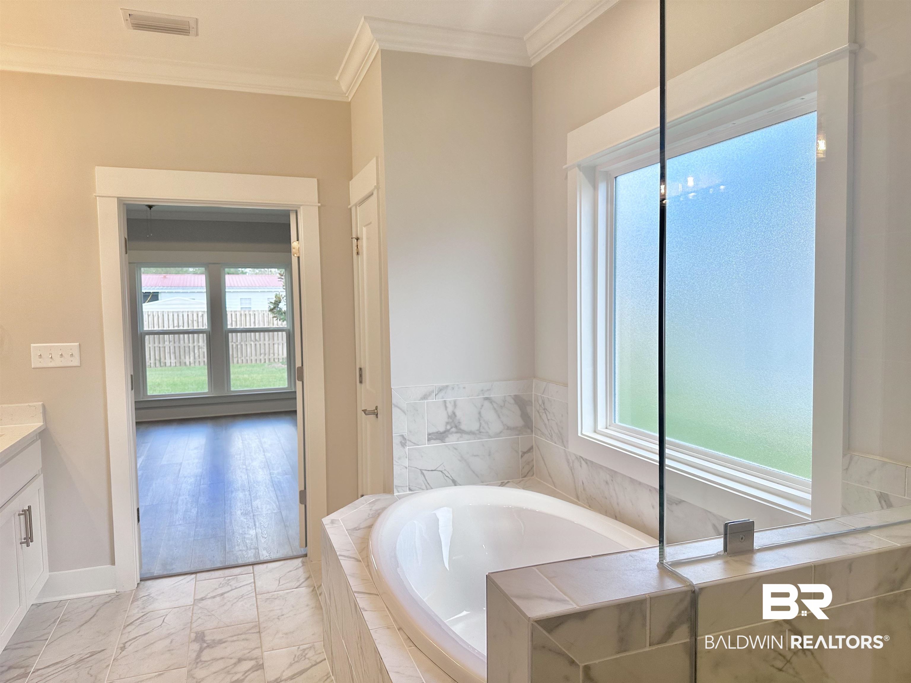 634 Kitfox Avenue Fairhope, AL 36532 - Photo 19 of 33 Bathroom featuring vanity, crown molding, tiled tub, and plenty of natural light