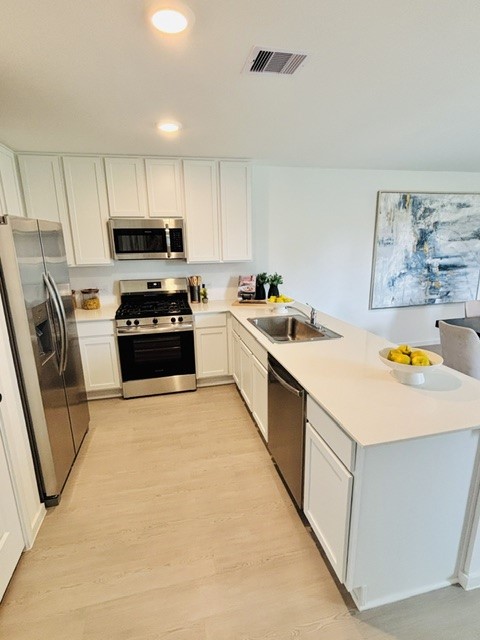 2126 Mosaic Vly Court Angleton, TX 77515 - Photo 7 of 40 a kitchen with stainless steel appliances a stove a sink a microwave and refrigerator
