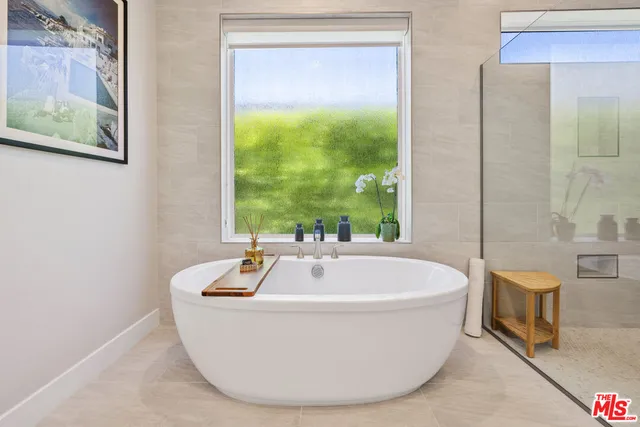 a white bath tub sitting in a bathroom next to a window