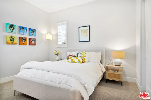 a bedroom with bed and painting on the wall