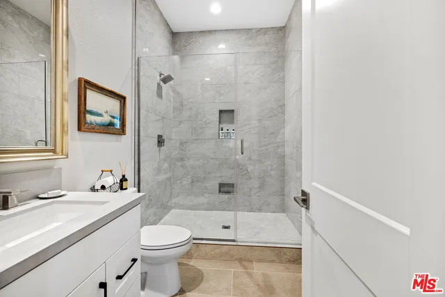 a bathroom with a granite countertop sink toilet and shower