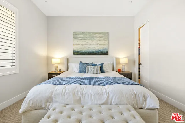 a bedroom with a bed and a painting on the wall