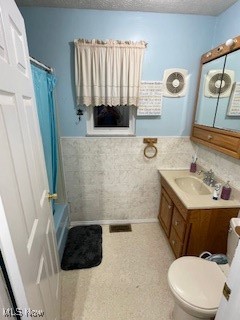 10682 Ravenswood Road Ravenswood, WV 26164 - Photo 19 of 46 Full bathroom featuring vanity, tile walls, shower / bathtub combination with curtain, toilet, and a textured ceiling
