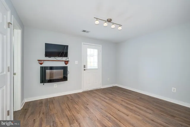 a view of a room with wooden floor and fan